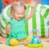BRIGHT STARTS Zenélő, világító játék Press & Glow Spinner 6hó+